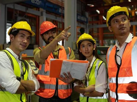 Engineers in high-visibility gear reading a plan on site.