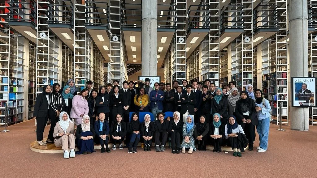 A school group photographed together inside a library.