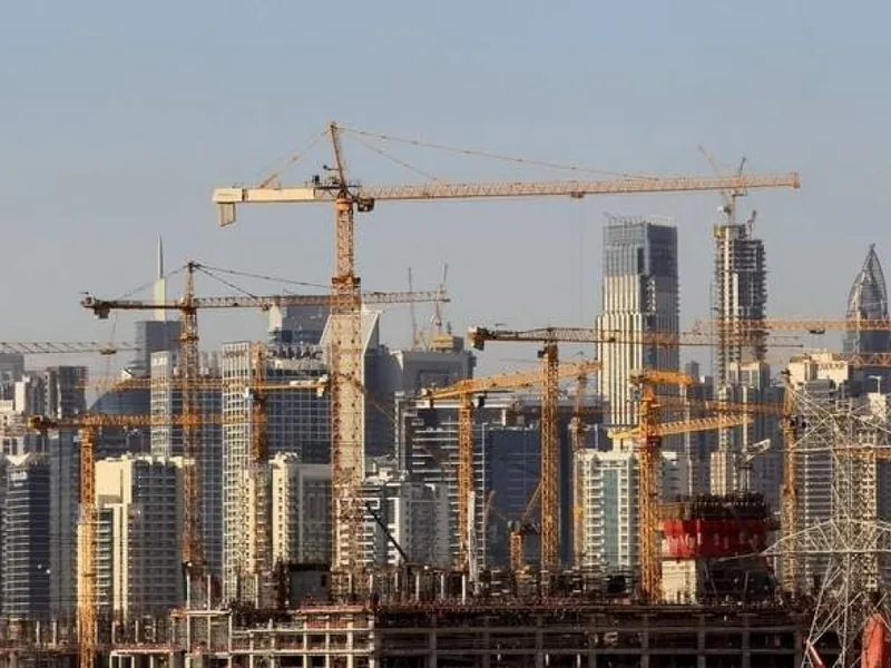 Cranes and towers under construction across a city skyline.