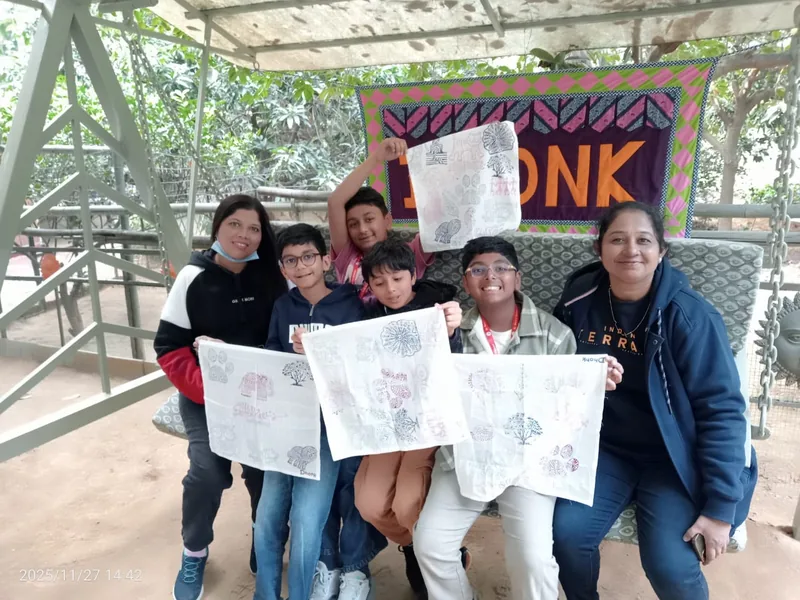 Students holding up their work at an in-school outreach session.