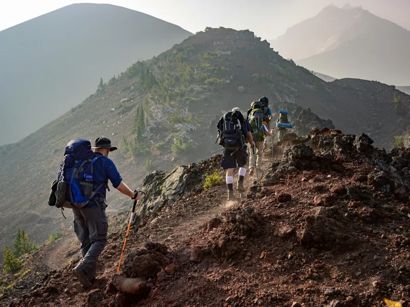 Trekkers on a ridge trail with packs.